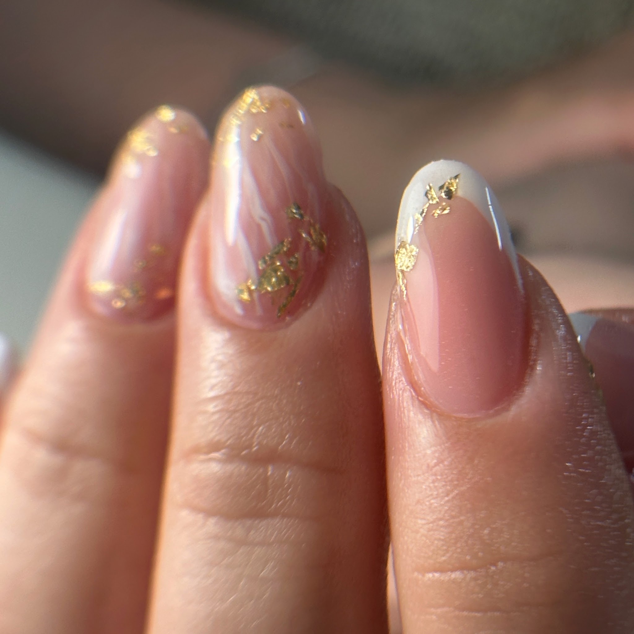 Nude French nagels met goudfolie, van dichtbij